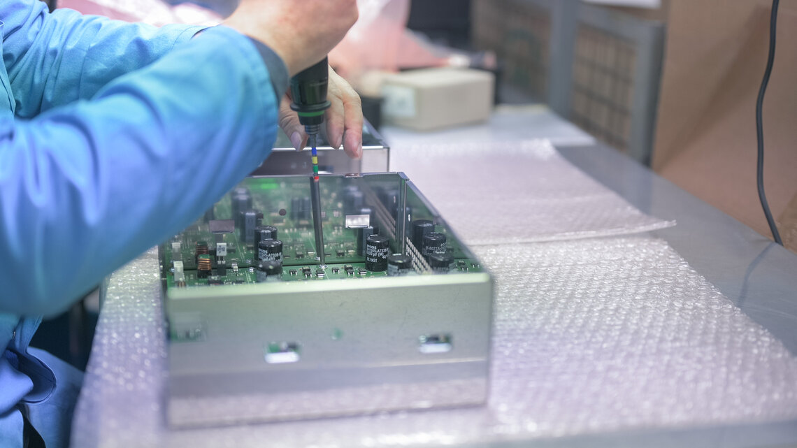 Employee assembling a product in electronics production